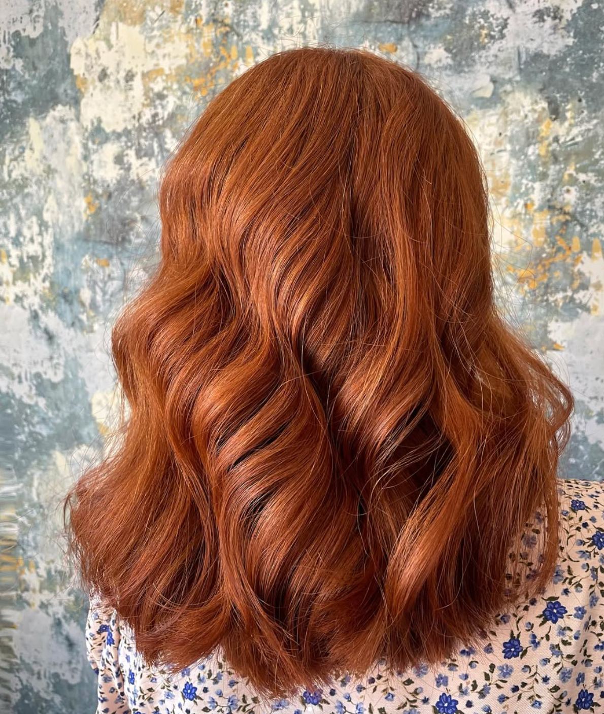 Glossy copper-coloured hair styled with loose waves